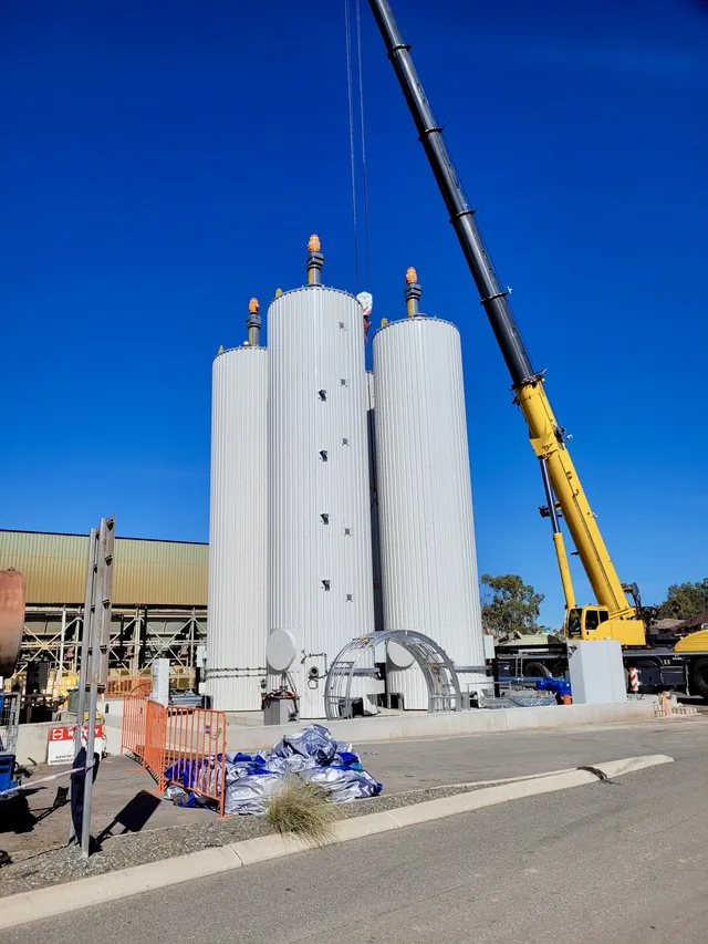 Crane lifting alongside storage silos on a Combo Constructions industrial site